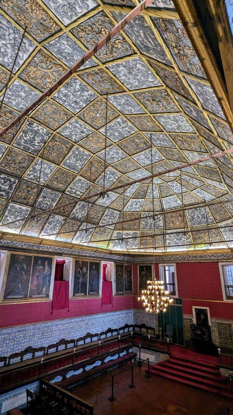 Hall with a painted coffered ceiling and red walls in Coimbra