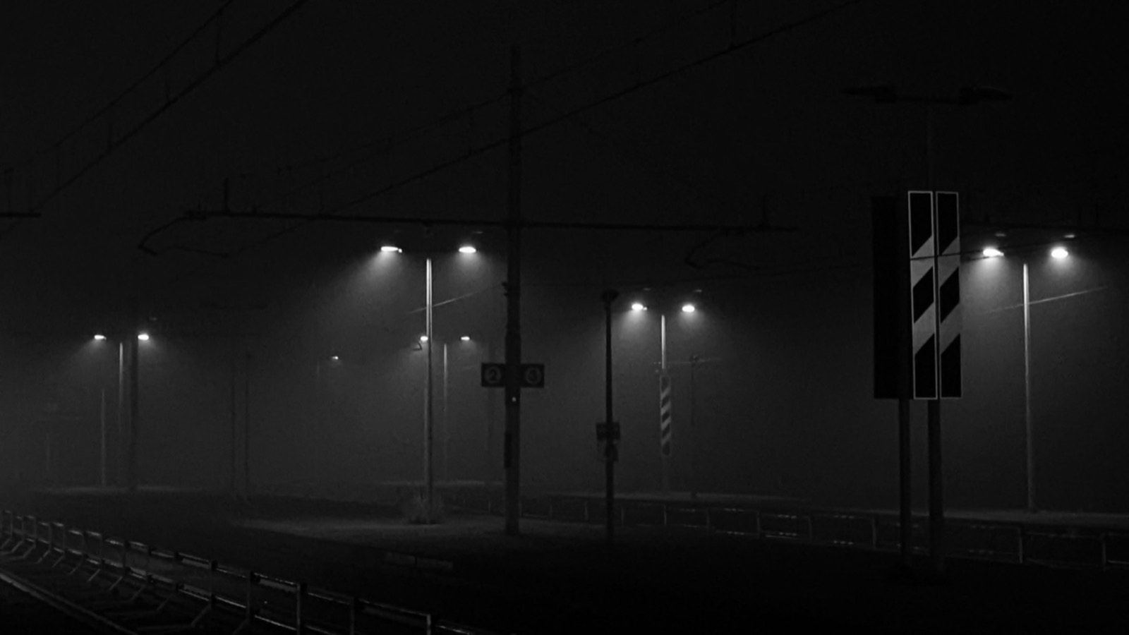 Railway platform lights in fog at night